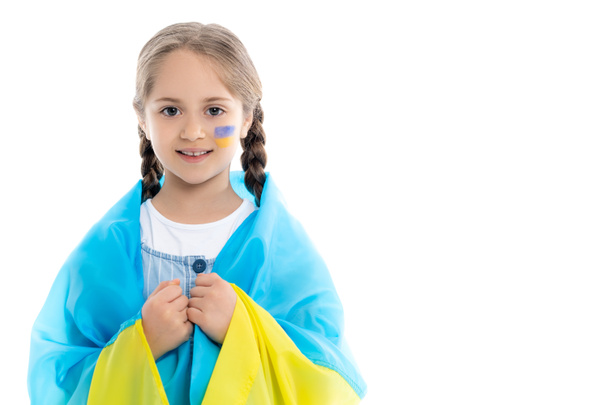 patriotic ukrainian girl with national flag on shoulders looking at camera isolated on white - Foto, immagini