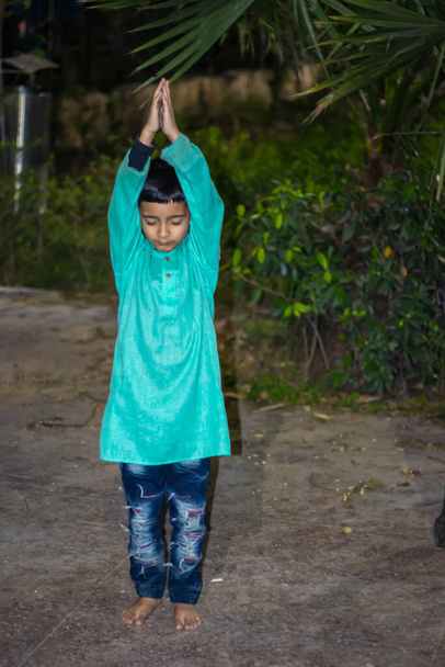 bambino che medita in abito tradizionale la sera da diverse angolazioni - Foto, immagini