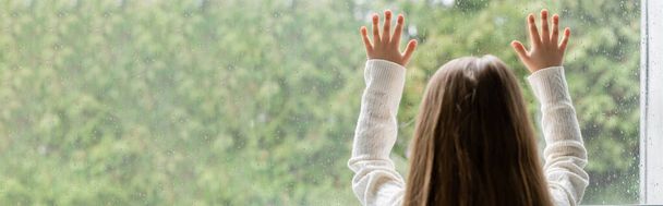 back view of girl touching window with raindrops, banner - Photo, Image