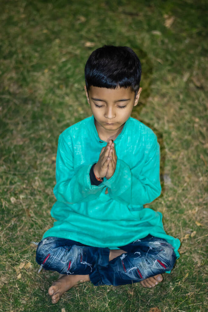 criança jovem meditando em vestido tradicional à noite de ângulos diferentes - Foto, Imagem
