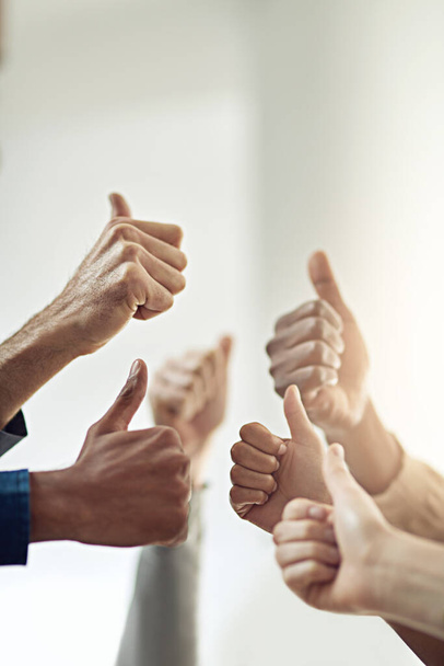 Victory achieved. Closeup shot of a group of businesspeople giving thumbs up together. - 写真・画像