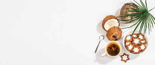 Glutenvrije en lactosevrije kokoskoekjes. Zelfgemaakte gezonde gebakjes, groene thee, zonnige ochtend. Een trendy hard licht, donkere schaduw, witte achtergrond, banner formaat - Foto, afbeelding