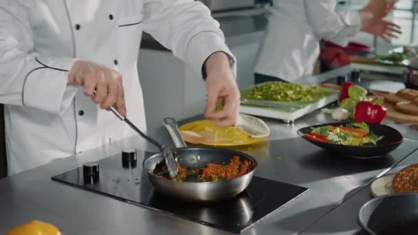 Profesjonalny kucharz przygotowujący przepis kulinarny z warzywami - Materiał filmowy, wideo