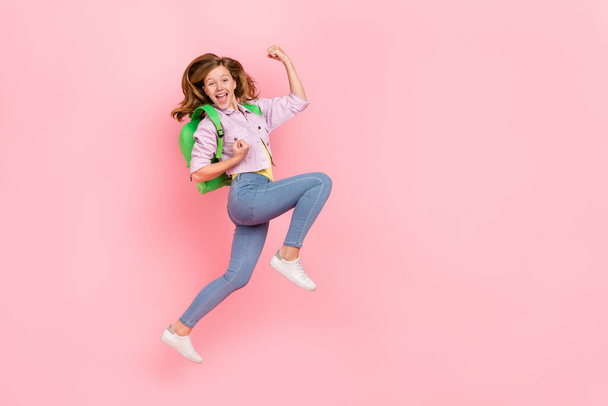 Photo of crazy champion lady jump rejoice raise fists scream goal wear backpack jacket isolated pink color background - 写真・画像