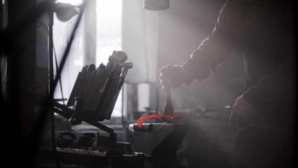 Кузнечная мастерская - человек, формирующий нагретый металл на наковальне с помощью формы и прессовочной машины - Кадры, видео