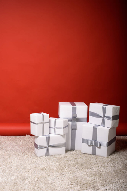 set di regali in posizione verticale sullo sfondo, su sfondo rosso, spazio libero, cartolina - Foto, immagini