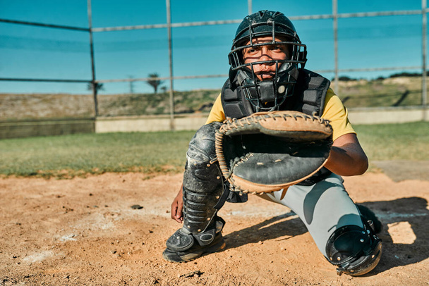 Hes the one with the best catching skills. Shot of the catcher sitting in position to catch the ball. - Photo, Image