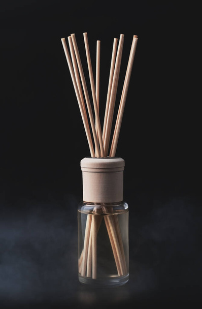 Fles van aroma diffuser op een donkere achtergrond - Foto, afbeelding