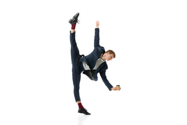 Studio shot of young male ballet dancer wearing business suit dancing isolated on white studio background. Business, start-up, art, work, caree, inspiration concept. - Photo, image