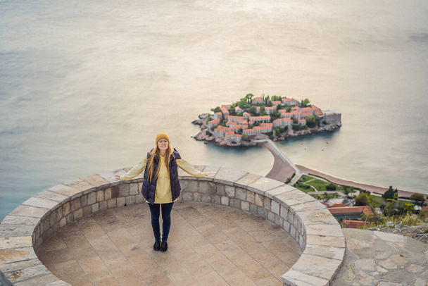 Woman tourist on background of beautiful view of the island of St. Stephen, Sveti Stefan on the Budva Riviera, Budva, Montenegro. Travel to Montenegro concept - Foto, afbeelding