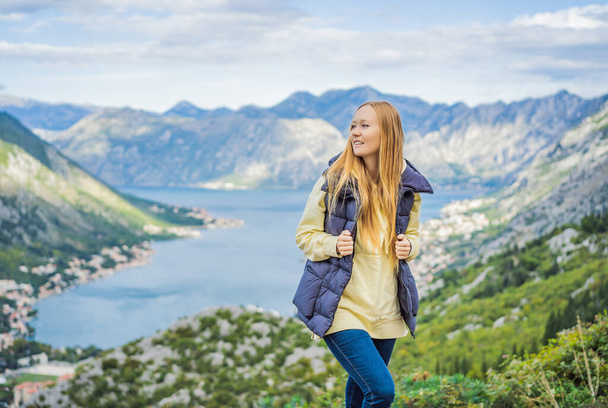Woman tourist enjoys the view of Kotor. Montenegro. Bay of Kotor, Gulf of Kotor, Boka Kotorska and walled old city. Travel to Montenegro concept. Fortifications of Kotor is on UNESCO World Heritage - Foto, Bild