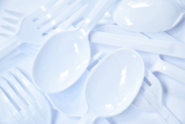  plastic lepel en vork voor eenmalig gebruik op witte ondergrond - Foto, afbeelding