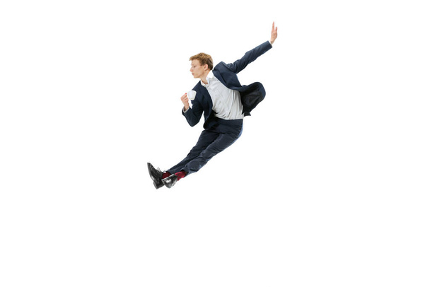 Portrait of flexible man in business style clothes dancing isolated on white studio background. Business, start-up, open-space, inspiration concept. - Foto, Bild