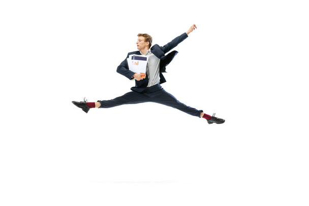 Young man in dark business suit jumping, flying isolated on white background. Art, motion, action, flexibility, inspiration concept. - Photo, image