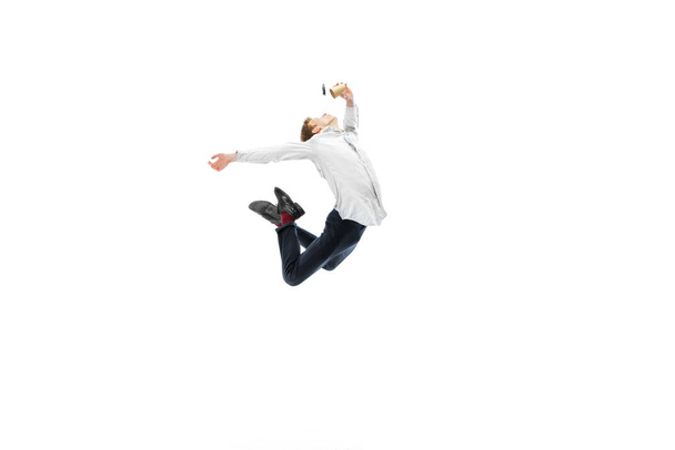 Studio shot of young male ballet dancer wearing business suit dancing isolated on white studio background. Business, start-up, art, work, caree, inspiration concept. - Foto, Imagem