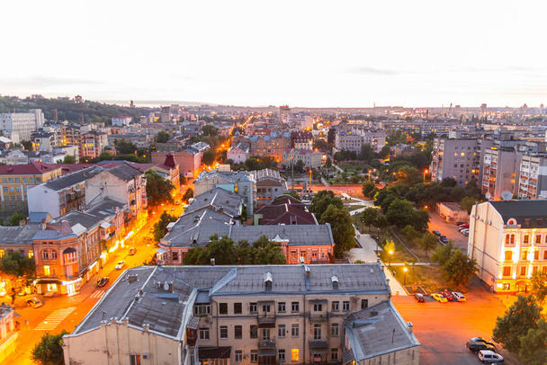 Oekraïne, Kiev 04 juli 2015: Luchtfoto panoramisch uitzicht op het centrale en historische deel, gebied van de stad Podil met residentiële gebouwen in de avond, tijdens de zonsondergang. Pre-revolutionaire gebouwen - Foto, afbeelding