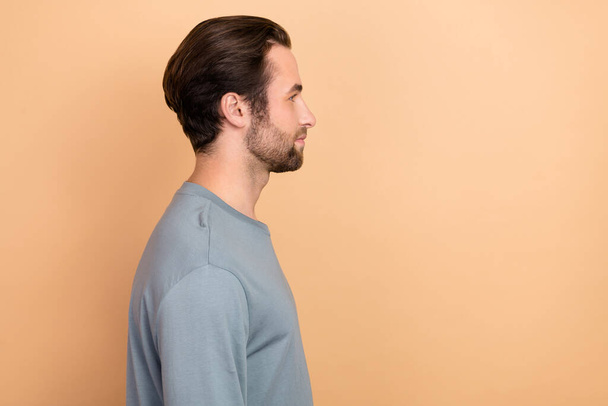 Profile side photo of young man look empty space wear casual clothes isolated over beige color background - Φωτογραφία, εικόνα