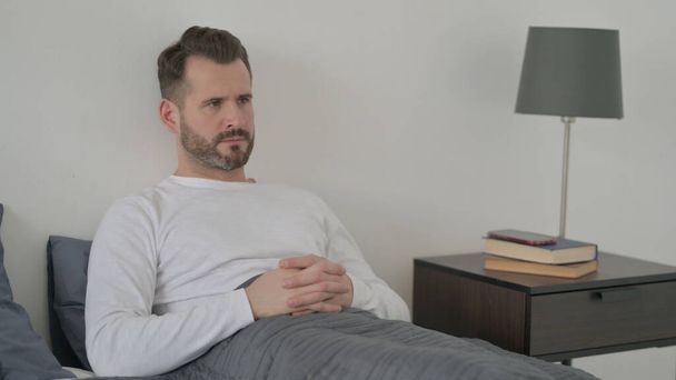Man Thinking while Sitting in Bed - Photo, image