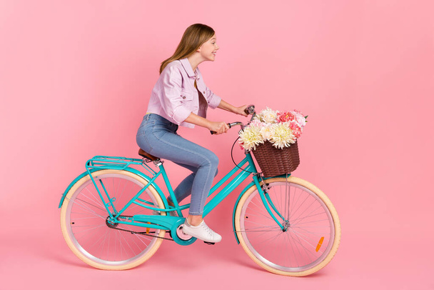 Profile photo of cheerful lady ride bike deliver flowers hurry shopping concept wear jacket isolated pink color background - Foto, Imagen