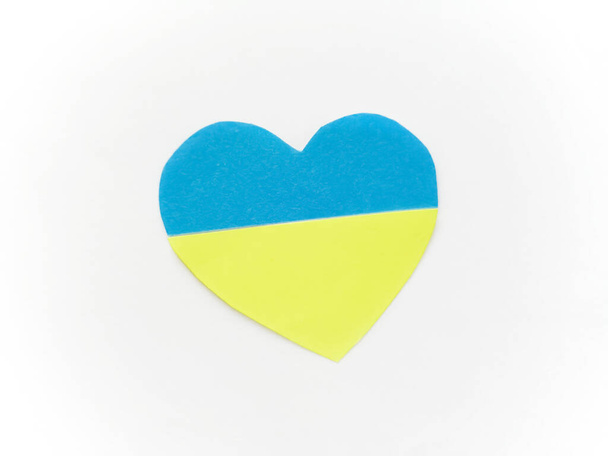 Application. Paper heart of blue and yellow halves on a white background. A heart made of paper. Flag of Ukraine. I love Ukraine. Ukraine is the heart. yellow-blue color of the flag of Ukraine. - Fotografie, Obrázek