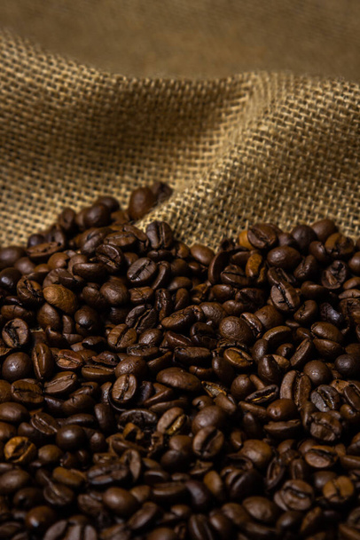Смажені кавові зерна на мішковині. Виробництво та обсмаження кавових зерен
 - Фото, зображення