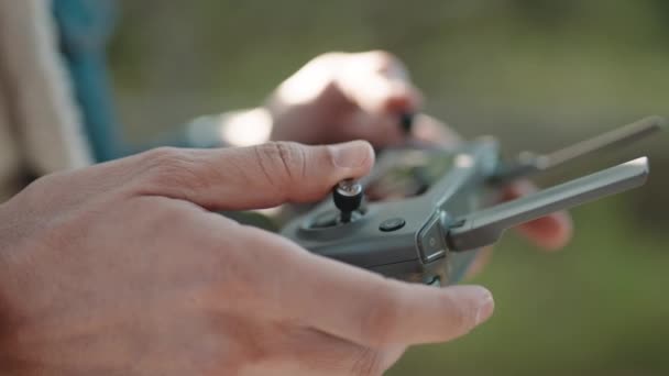 Egy drónkezelő keze, miközben egy négykopteres távirányítót irányít.. - Felvétel, videó