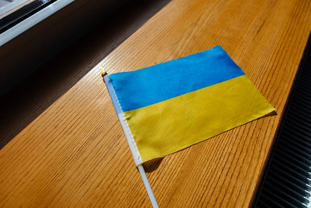 flag of ukraine blue yellow on table wooden background. - Valokuva, kuva