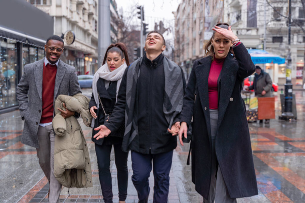 Čtyři multiraciální podnikatelé spolu chodí po dešti, zatímco mluví o obchodních plánech, zavřít - Fotografie, Obrázek
