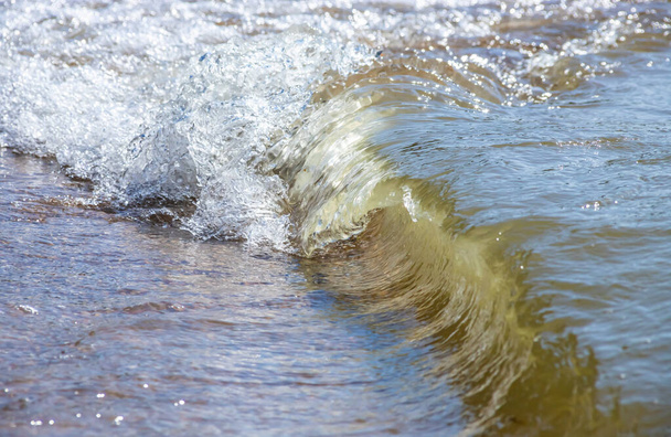 Close-up of sea foam on the sand beach with summer sunlight. - Fotoğraf, Görsel