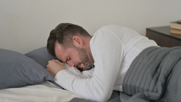 Ο άνθρωπος κλαίει ενώ κοιμάται στο κρεβάτι - Φωτογραφία, εικόνα