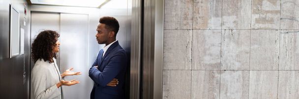 Young African Businesspeople Having Conversation In Elevator - Foto, imagen