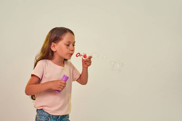 Girl with heart rhinestones blowing soap bubbles - 写真・画像