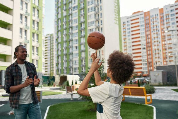 Father clap for son spin basketball ball on finger - Foto, imagen