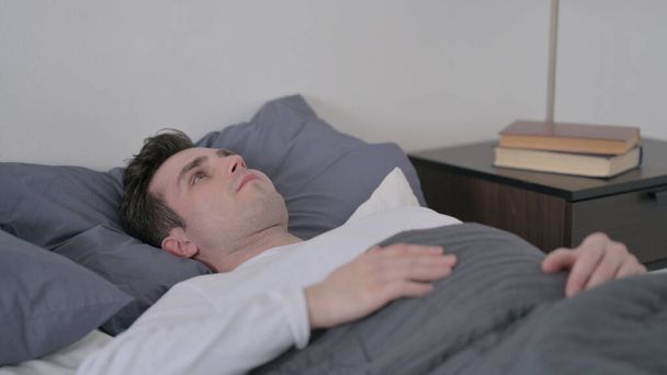 Uomo sdraiato a letto incapace di dormire - Foto, immagini