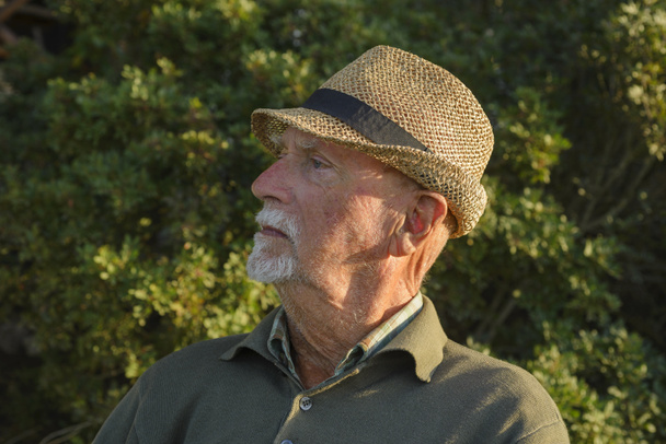 Retrato de un anciano italiano con sombrero de paja y ojos azules, en una madera - Foto, Imagen
