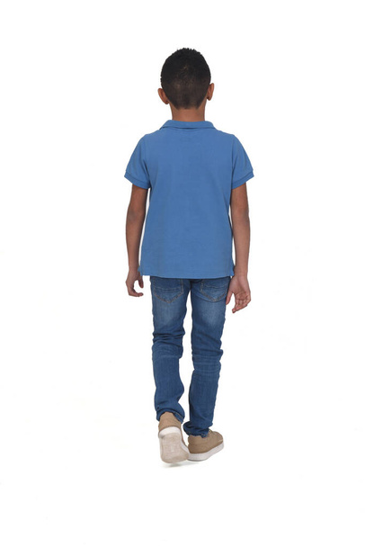 rear view of boy with jeans walking on white background - Foto, Imagen