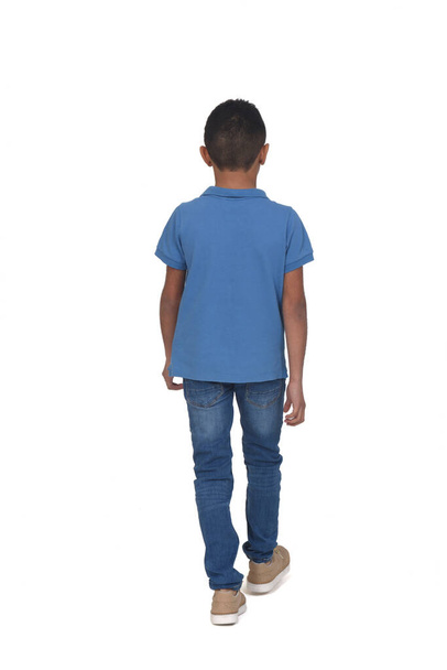 vista trasera del niño caminando sobre fondo blanco - Foto, Imagen