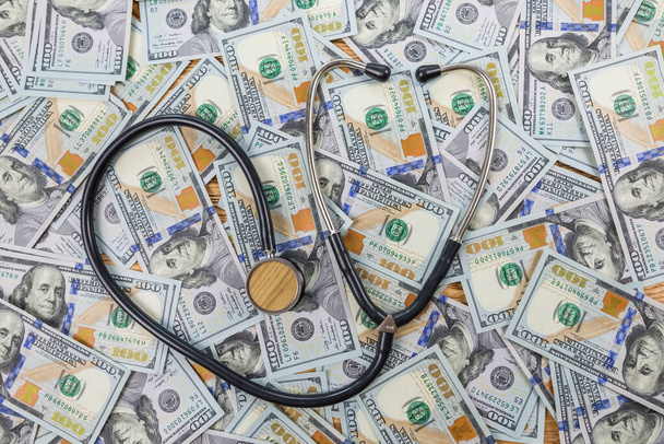 medizinisches Stethoskop auf Dollar-Hintergrund. Geschäfts- und Medizinkonzept. - Foto, Bild