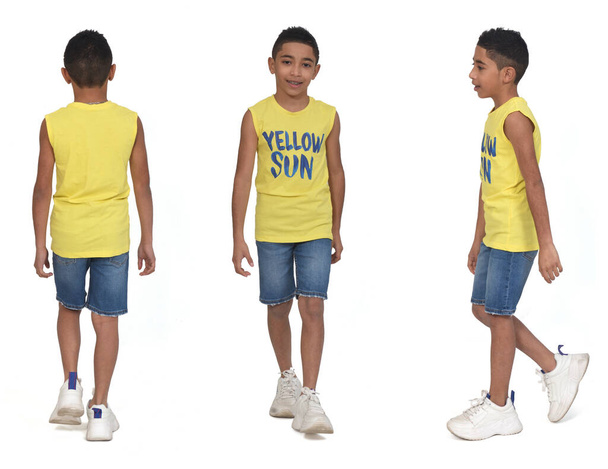 verschillende poses van dezelfde jongen gekleed in shorts en mouwloos lopen op witte achtergrond - Foto, afbeelding