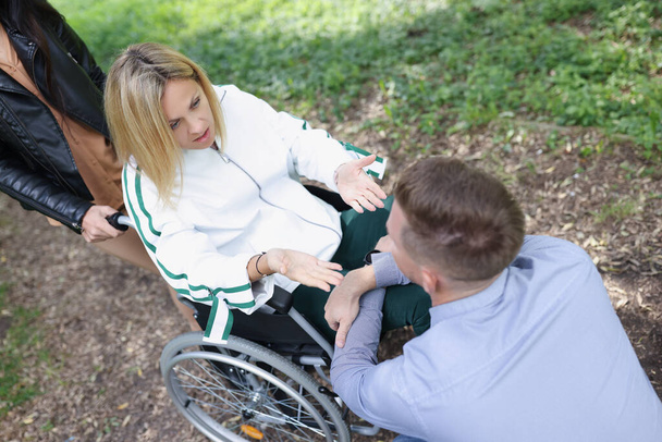 Donna in sedia a rotelle comunica con l'uomo nel parco - Foto, immagini