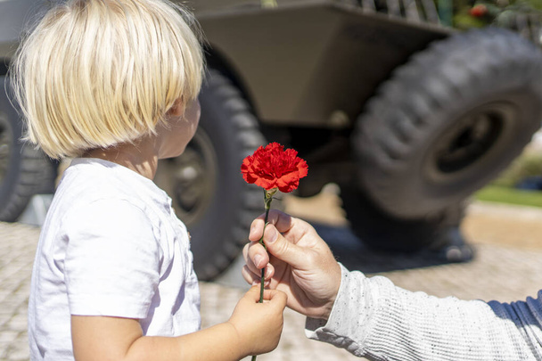 25 of April, celebration of 50 Years, Portugal freedom day. Revolution of the Carnations 1974. Army tank and red clove - Foto, Imagen