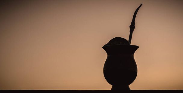 The chimarrao, or mate, is a drink produced by infusing the yerba mate plant in boiling water, in a bowl with a pump, traditional for winter in South America. - Photo, Image