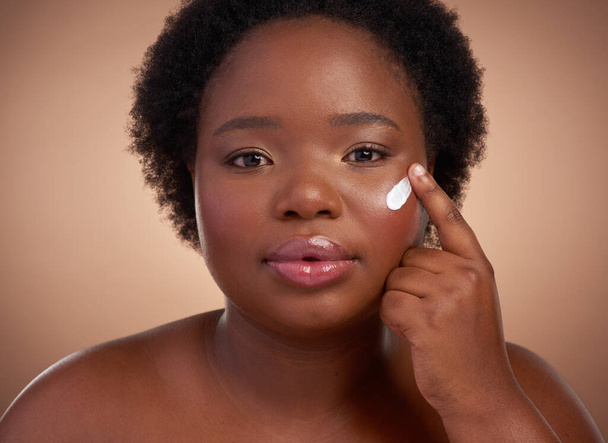 A skincare regime is a daily activity. Studio portrait of a beautiful young woman posing against a brown background. - Foto, Imagen