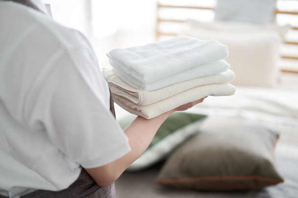Asijky žena skládací ručníky a dát je pryč - Fotografie, Obrázek