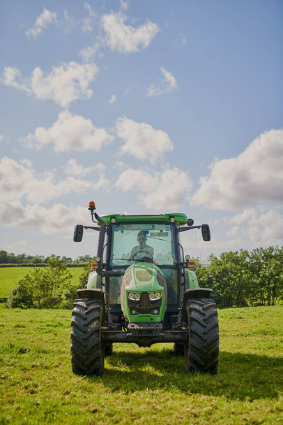 Chaque agriculteur en a besoin. Plan complet d'un tracteur vert sur un terrain agricole ouvert. - Photo, image