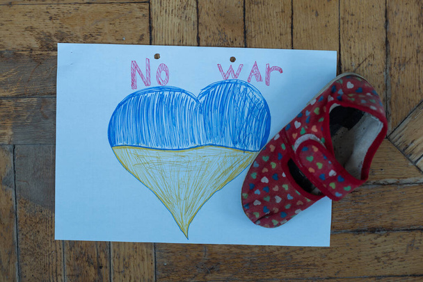 childrens shoes and the flag of Ukraine, the war - Foto, Imagem
