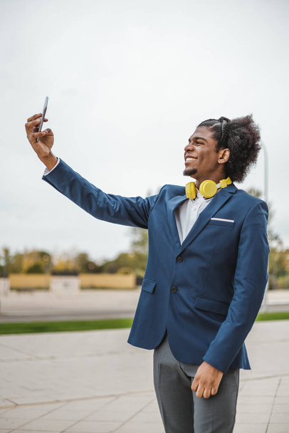 vue latérale verticale de jeune afro-américain prenant un selfie - Photo, image