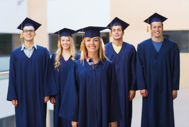 group of smiling students in mortarboards - Valokuva, kuva