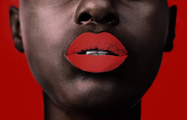 Read my lips. Cropped shot of a womans face showing the lower half only on a red background. - Foto, Imagen