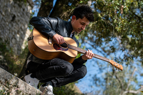 terni, Włochy 15 kwiecień 2022: chłopiec gra na gitarze w naturze - Zdjęcie, obraz